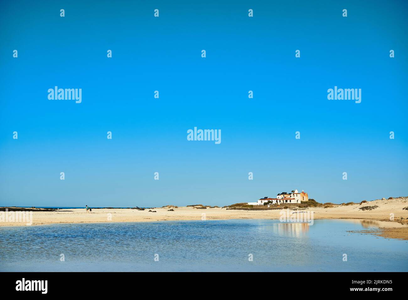 Landschaftsansicht des Strandes gegen den Atlantischen Ozean und Gebäude unter hellem bewölktem Himmel in Fuerteventura Spanien Stockfoto