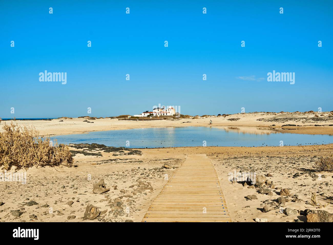 Blick auf die Promenade am Strand gegen den Atlantik und Gebäude unter dem hellen, bewölkten Himmel auf Fuerteventura Spanien Stockfoto