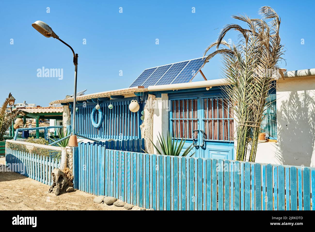 Alte Wohnhausfassaden mit Solarzellen auf Dächern gegen Sandstraße in Fuerteventura auf den Kanarischen Inseln Spanien Stockfoto