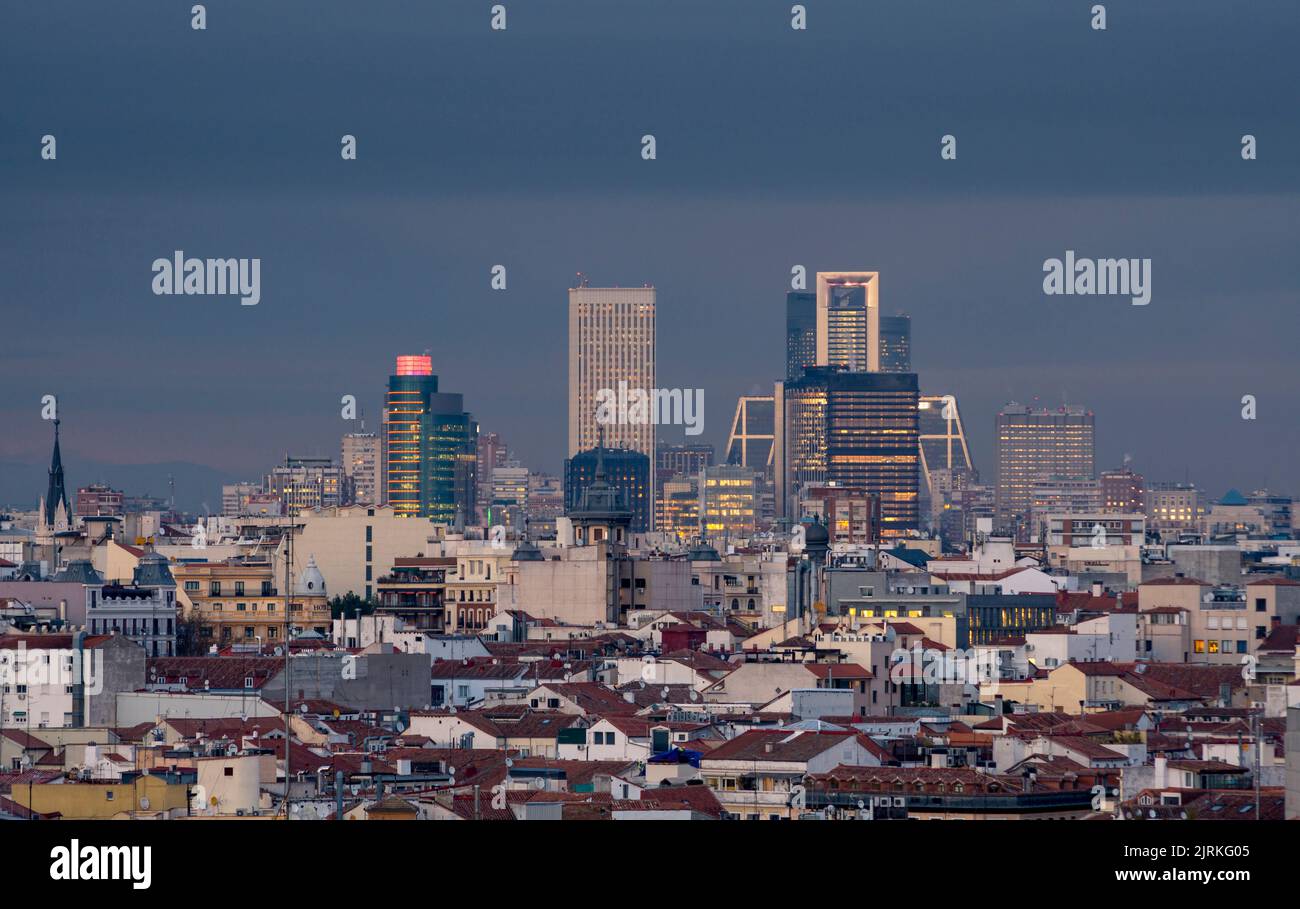 Luftaufnahme des dicht bebauten Viertels von Madrid mit modernen Wolkenkratzern zwischen Häusern mit roten Dächern und historischen Gebäuden Stockfoto