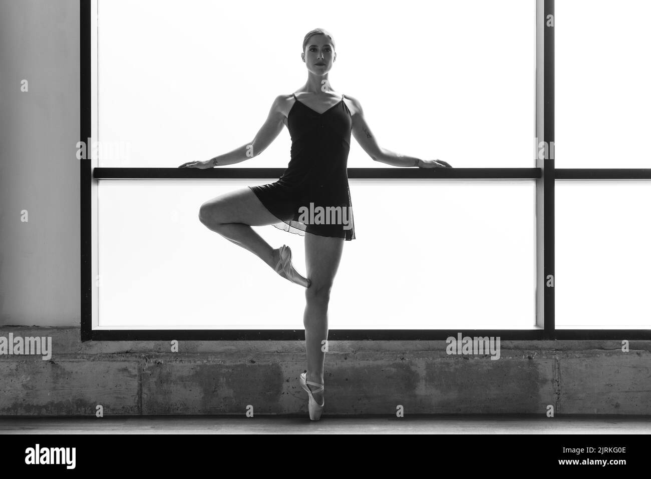 Foto der jungen Ballerina, die im Tanzstudio auf Zehenspitzen posiert Stockfoto