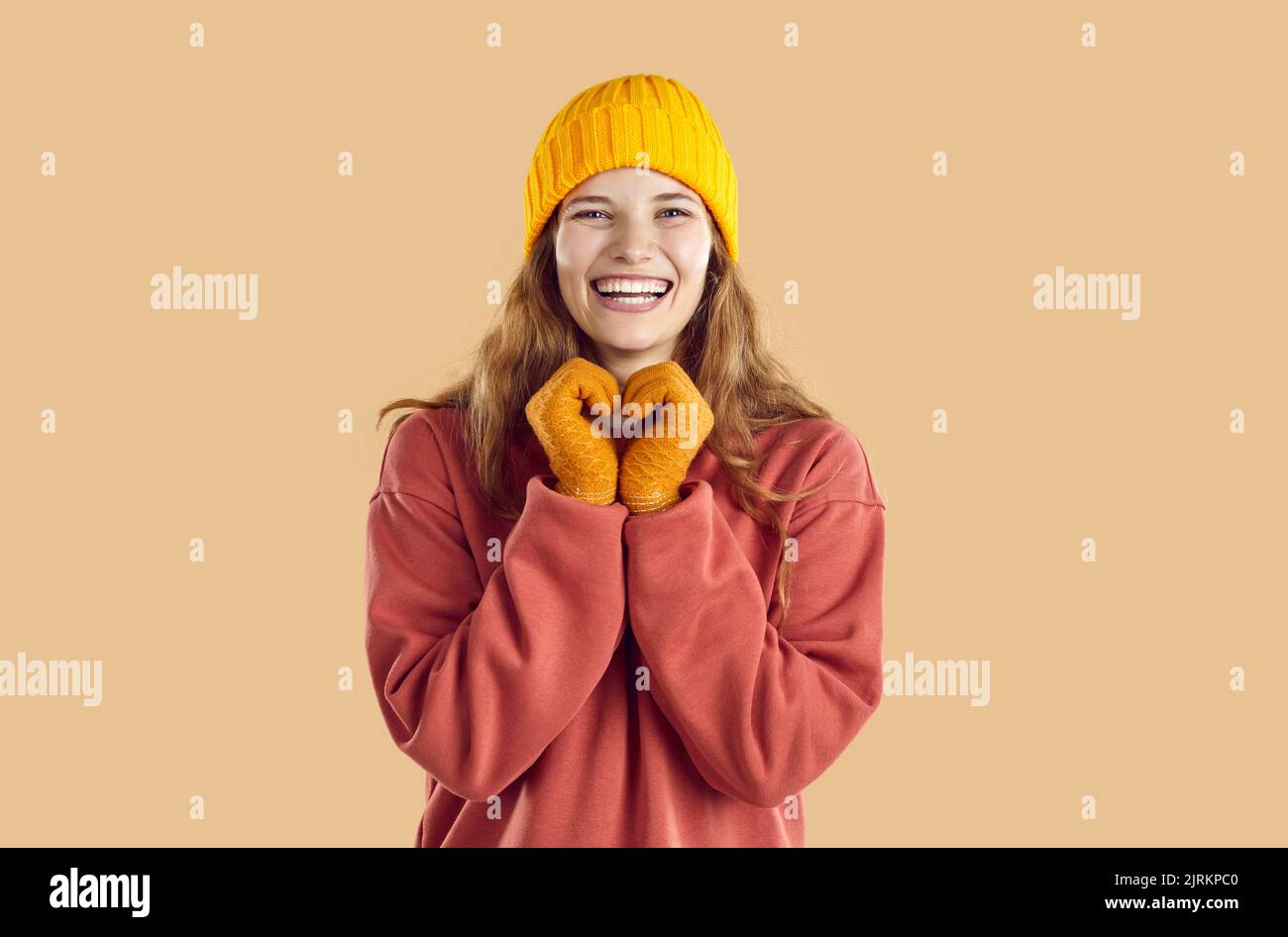 Porträt einer fröhlich lächelnden jungen Frau in warmem Herbst-Sweatshirt, Hut und Handschuhen Stockfoto