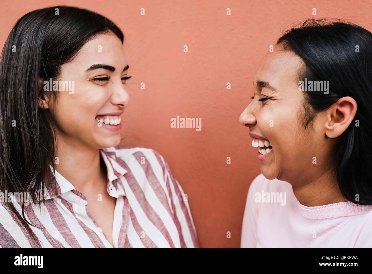 Hispanische Freunde, die Spaß haben, gemeinsam im Freien zu lachen - Fokus auf das rechte Mädchenauge Stockfoto
