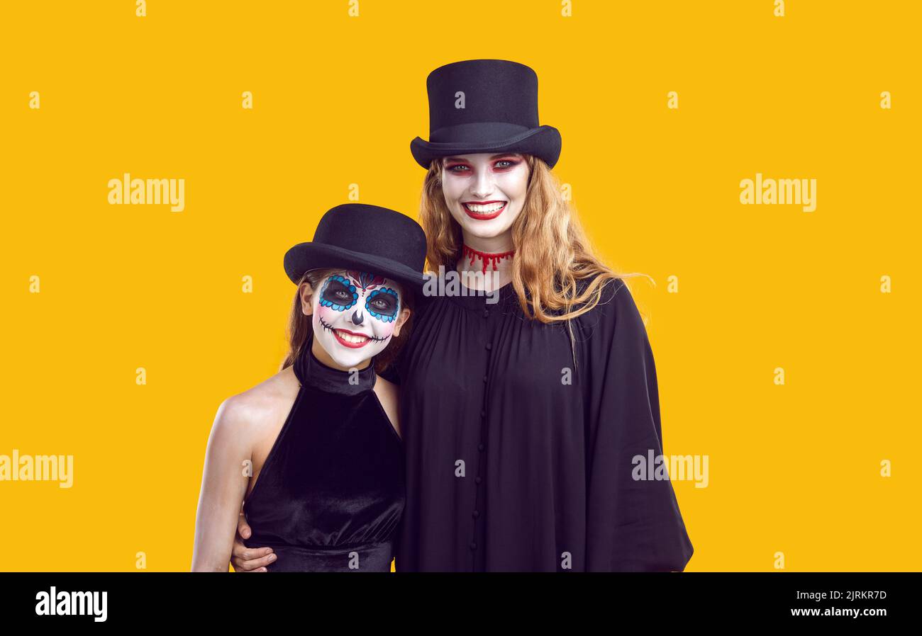 Fröhliche junge Frau und ihre Tochter im Teenageralter feiern gemeinsam traditionelle Halloween-Ferien. Stockfoto