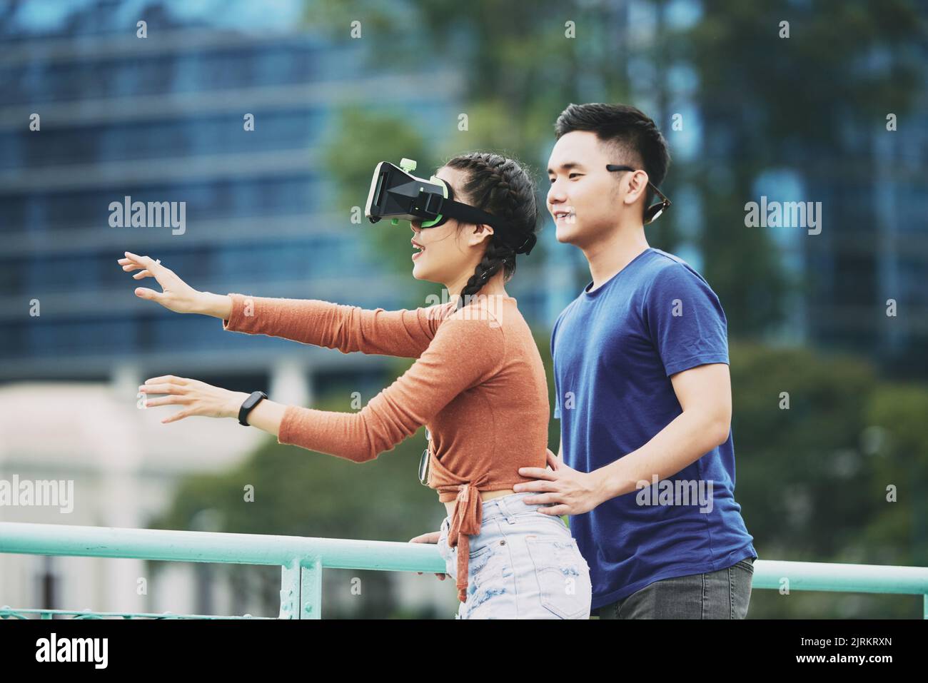 Junge Frau in Brille erkunden virtuelle Realität Stockfoto