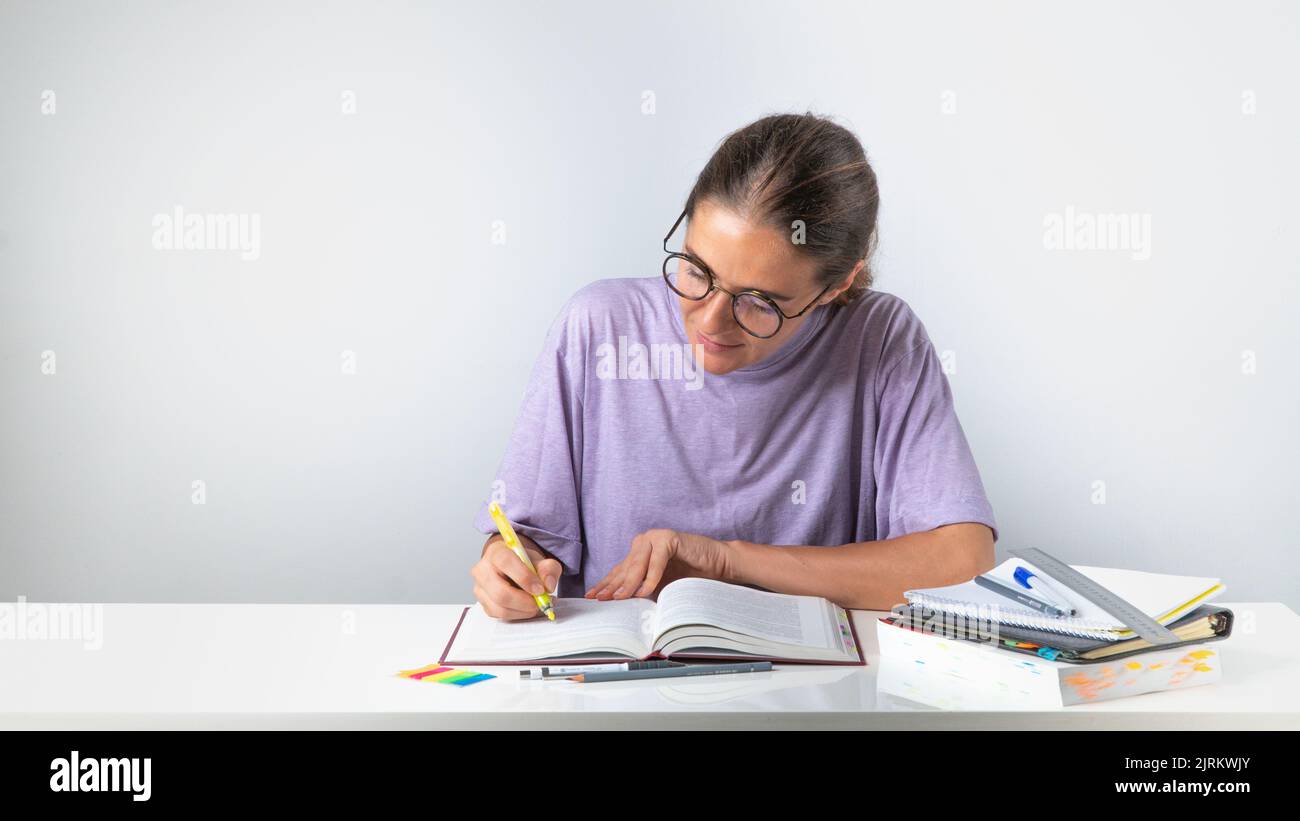 Der Teilnehmer hebt den Textmarker im Lehrbuch während der Schulung hervor Stockfoto