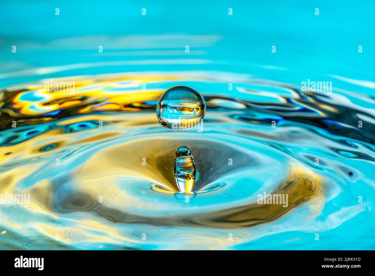 Wassertropfen Spritzer isoliert auf türkisfarbenem Hintergrund. Stockfoto