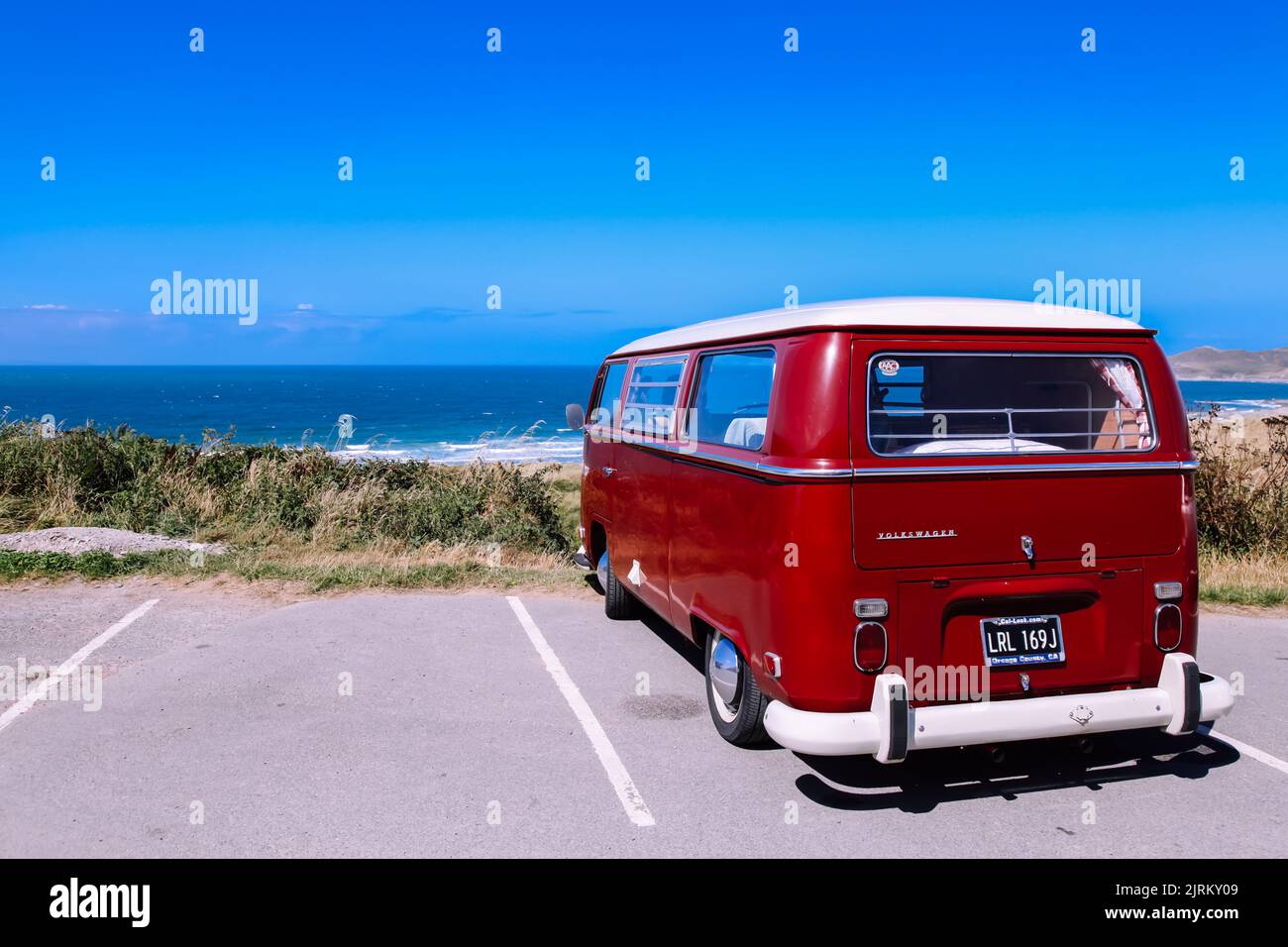Ein VW Volkswagen Classic Campervan parkt am Strand der britischen Küste mit blauem Himmel, Woolacombe Bay, North Devon, England, Großbritannien Stockfoto
