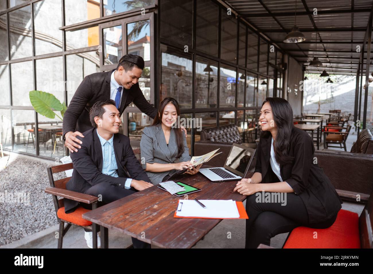 asiatischer Arbeiter während einer Pause beim Treffen im Café Stockfoto