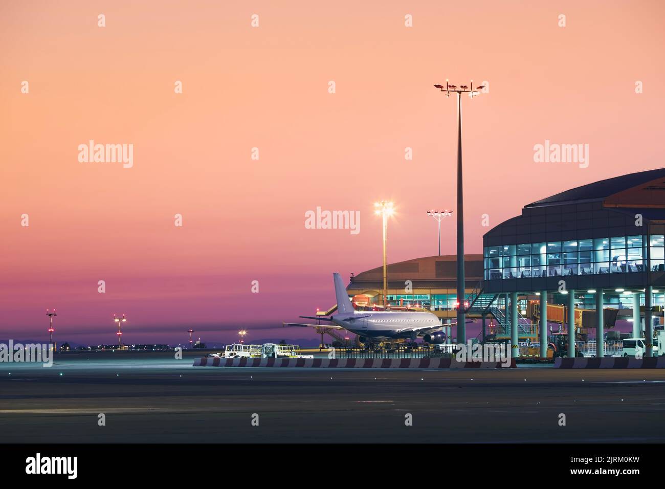 Vorbereitung des Flugzeugs vor dem Flug. Flughafen bei farbenfrohem Sonnenaufgang. Stockfoto