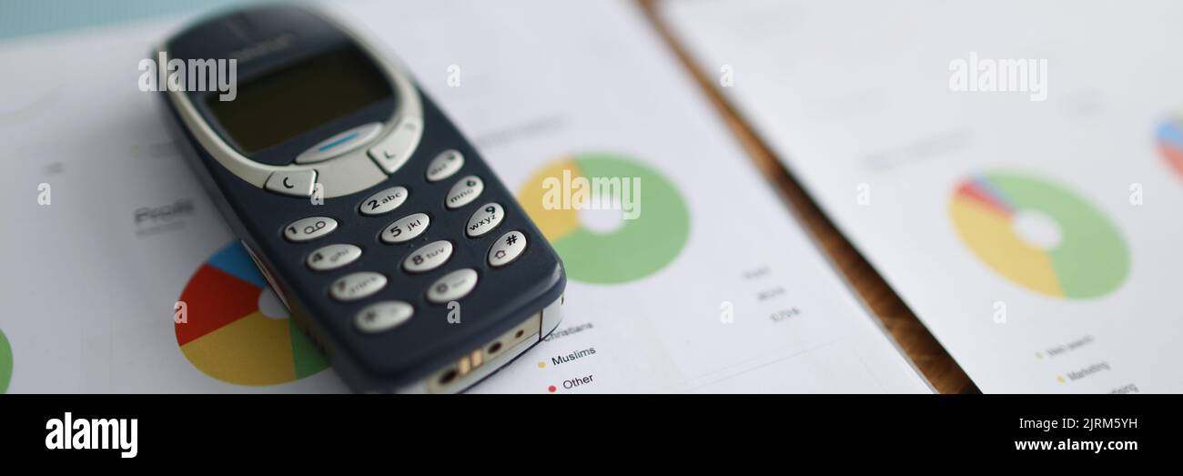 Nokia 3310 Mobiltelefon liegt auf Dokumenten mit Grafiken in Nahaufnahme Stockfoto