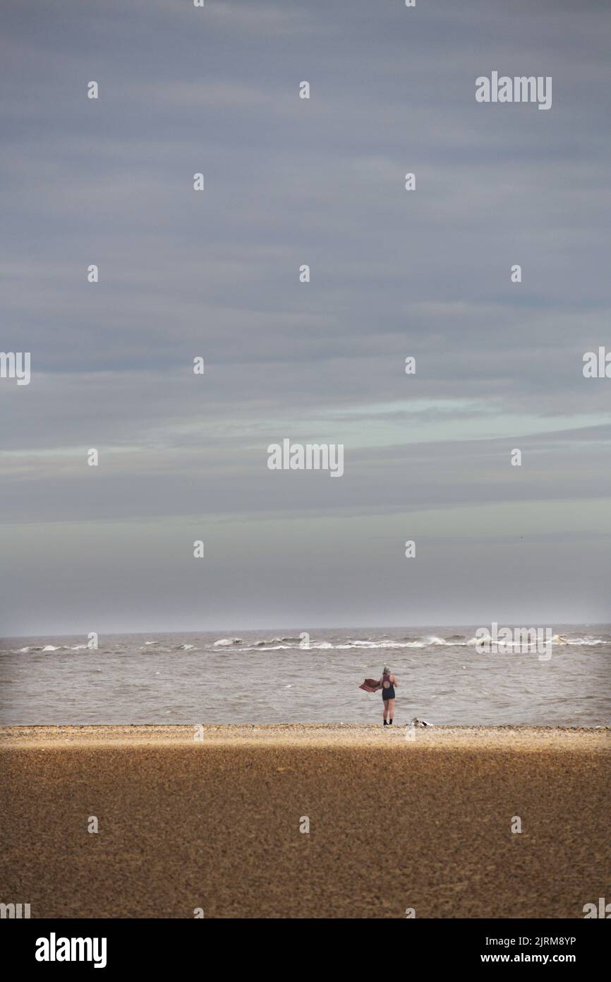 Einsame weibliche Baderin am Pakefield-Strand lowestoft suffolk im november Stockfoto