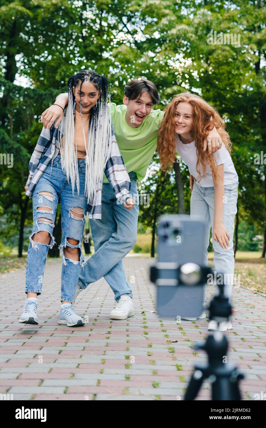Gruppe von Freunden, die Spaß haben, mit dem Handy zu fotografieren und dabei lustige Gesichter zu machen. Freie Zeit am Wochenende. Freundschaft, Menschen und Technologiekonzept Stockfoto
