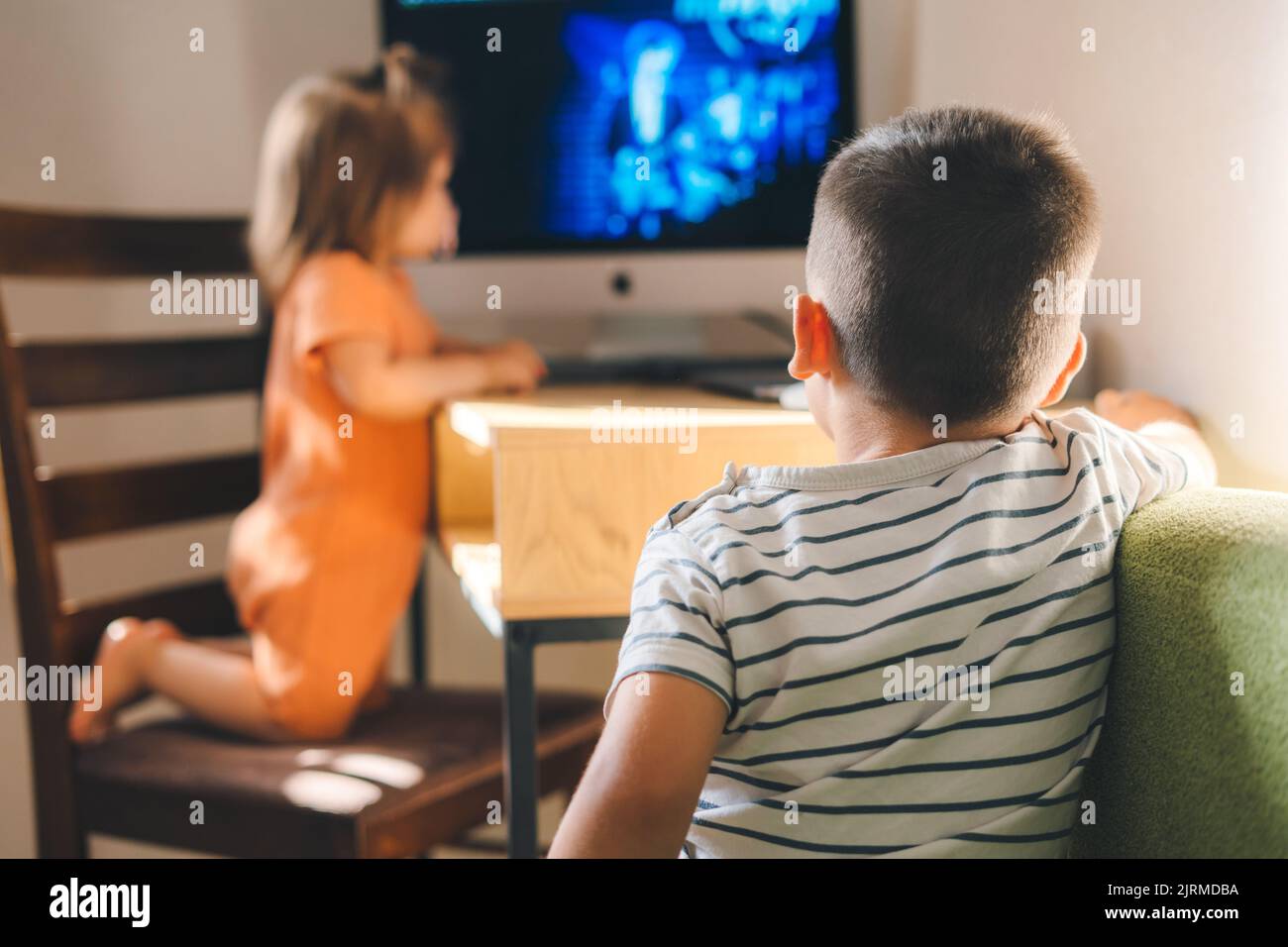 Bruder und Schwester schauen zu Hause fern. Kinder genießen Freizeit beim Ansehen von Videos. Neues Technologiebildungskonzept Stockfoto