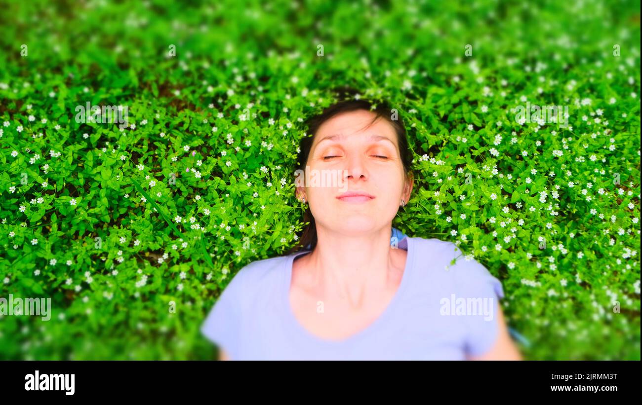 Draufsicht Porträt einer hübschen jungen Frau auf einem Gras entspannen Foto herunterladen Stockfoto