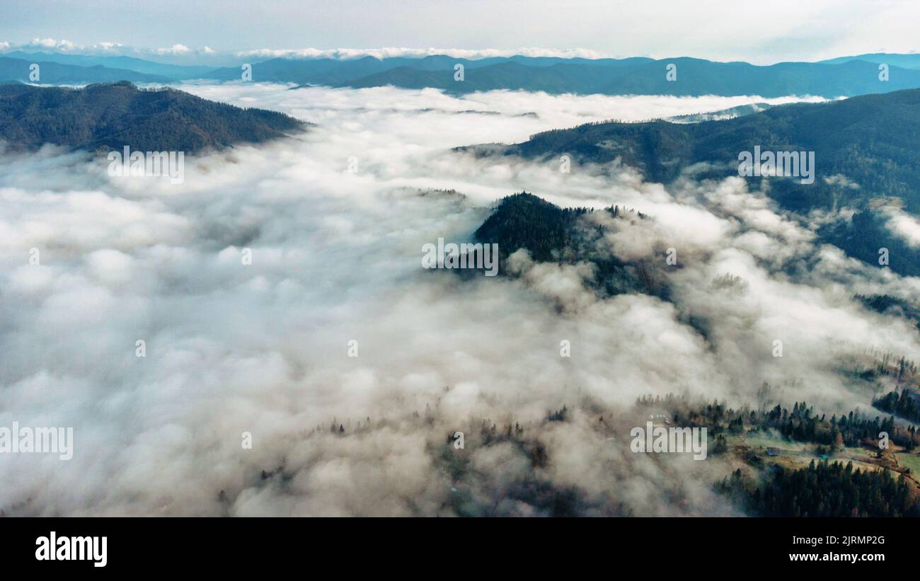 Berglandschaft. Ein verträumter Blick auf ein nebeliges Tal in den Karpaten, Ukraine. Luftaufnahme einer Panorama-Drohne Stockfoto