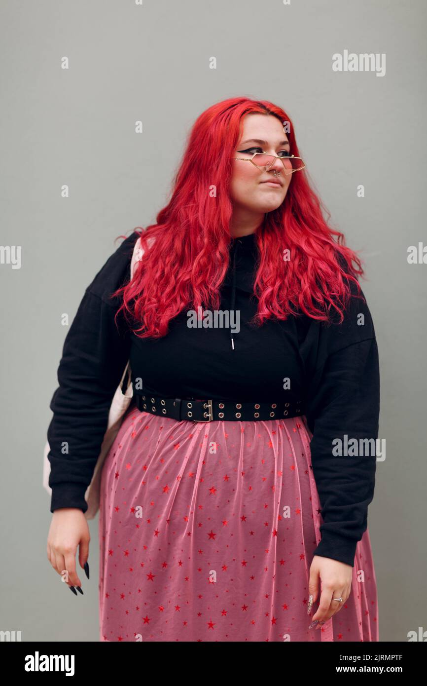 Plus Größe Übergewicht Fett Körper positive lgbtq Frau mit roten Haaren und rosa Brille. Stockfoto