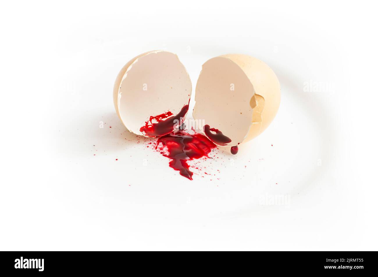 Zerrissene Eierschale mit einer Blutspur, isoliert auf Weiß. Abtreibungskonzept Stockfoto