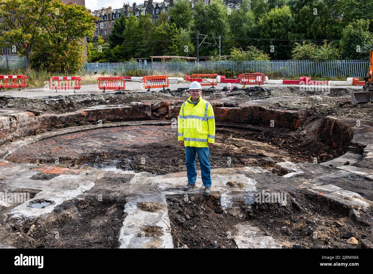 Meadowbank, Edinburgh, Schottland, Großbritannien, 25.. August 2022. Überreste des viktorianischen Eisenbahndepots St. Margaret's: Stadtarchäologen entdecken im Rahmen der Regeneration der Meadowbank einen viktorianischen Eisenbahnmaschinenschuppen und ein 20m-breites Drehscheibe (eines der frühesten Beispiele dieser Art). Der Standort wird für eine Wohnsiedlung entwickelt, aber die Überreste werden innerhalb der Wohnsiedlung erhalten bleiben. Im Bild: John Lawson, Ratsarchäologe. Kredit: Sally Anderson/Alamy Live Nachrichten Stockfoto