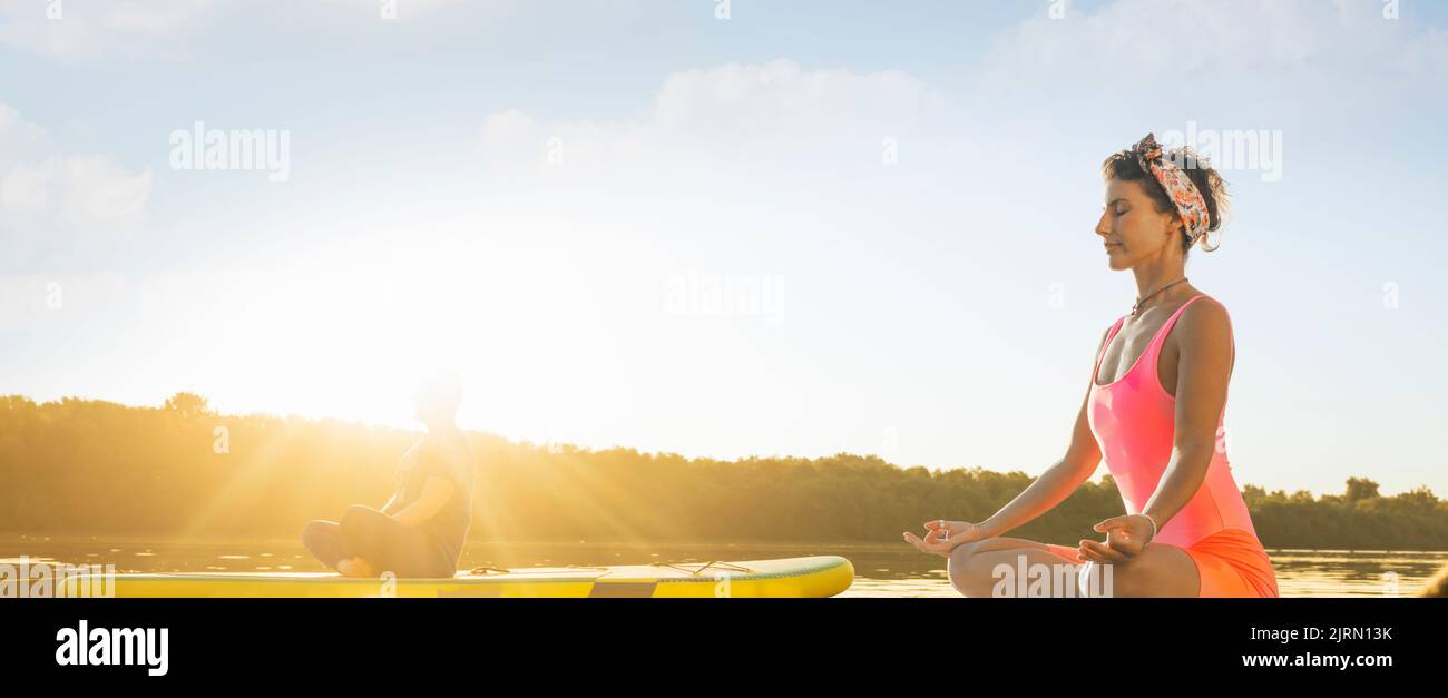 Frau und Mann meditieren während eines ruhigen Sommermorgens Stockfoto