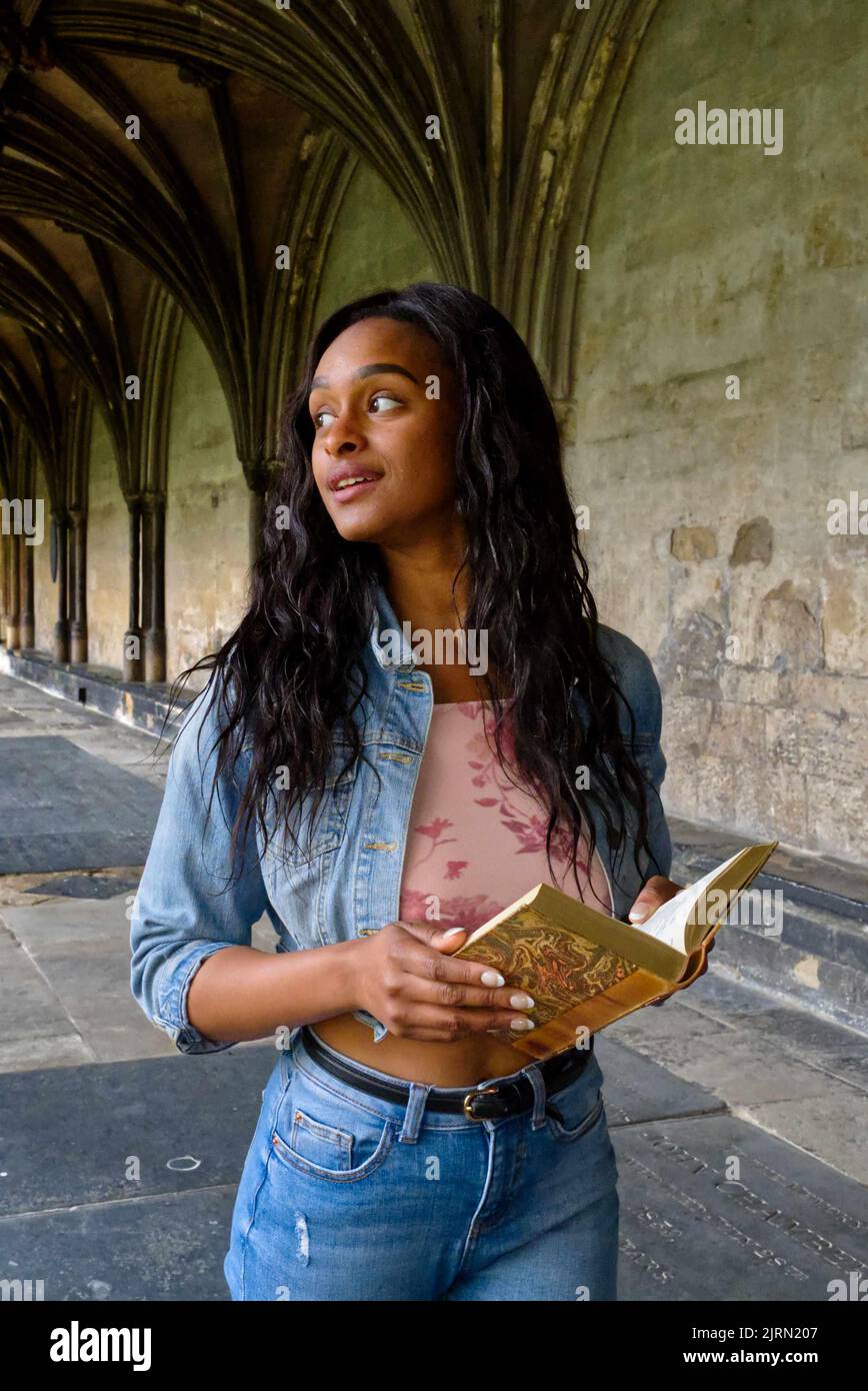 Junge, farbige Frau im Kloster einer Kathedrale in modernen Tüchern. Stockfoto