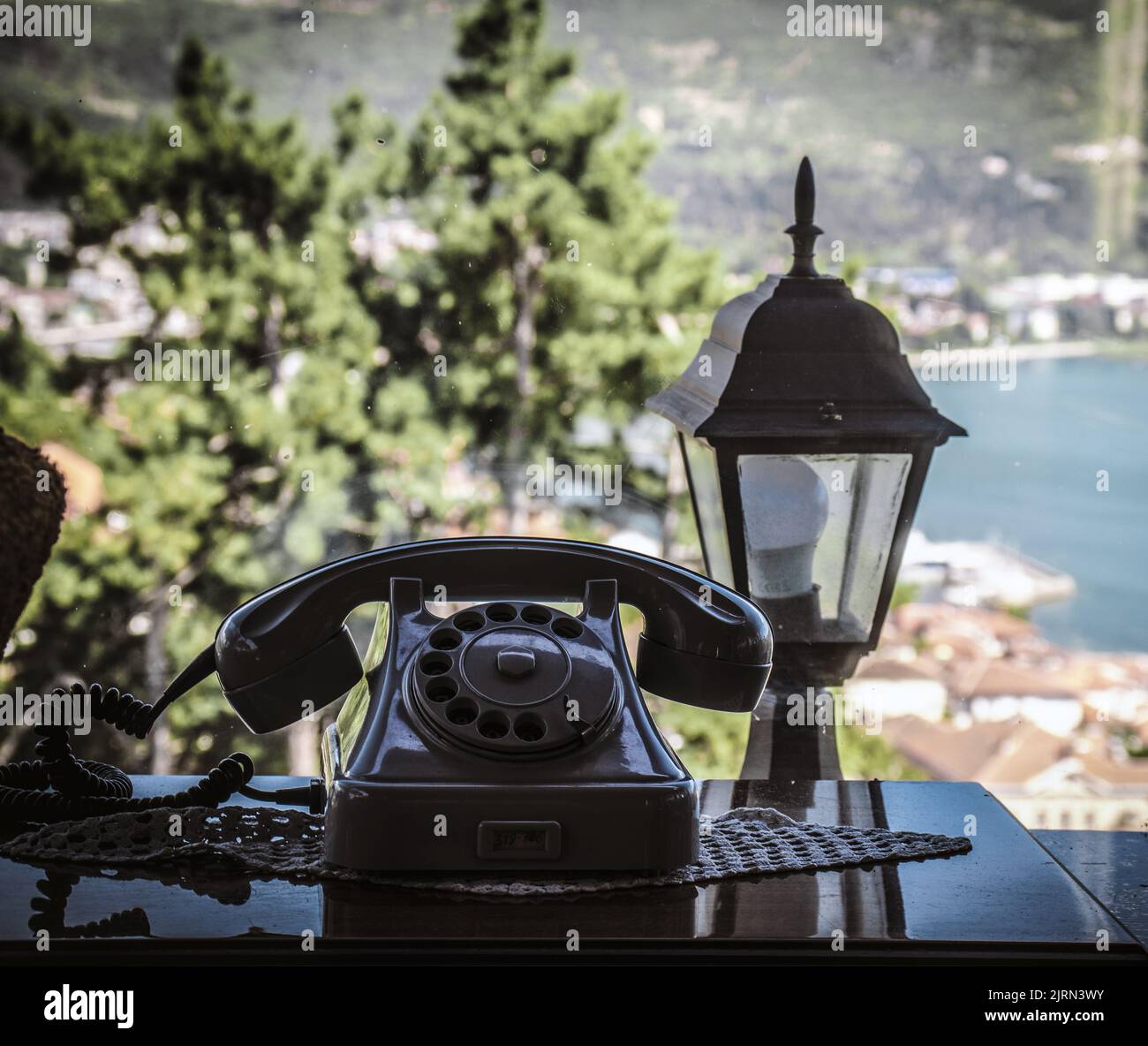 Ein altes schwarzes Telefon auf dem Tisch am Fenster Stockfoto