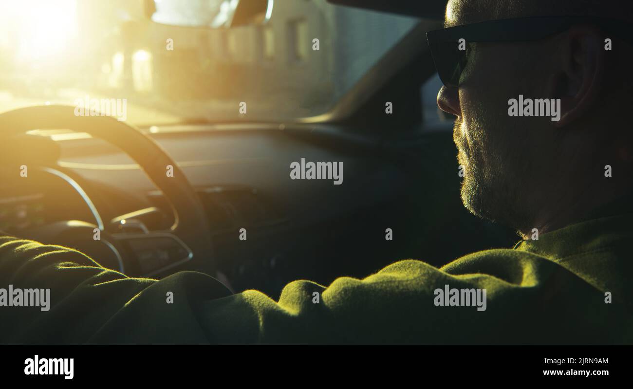 Kaukasische Männer Tragen Schwarze Sonnenbrillen Fahren Seine Moderne Sportliche Auto Während Szenischen Sonnenuntergang. Konzeptfoto Der Automobilindustrie. Stockfoto