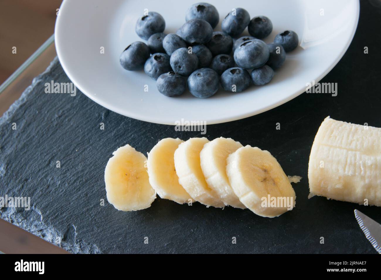 Gesundes Frühstück, frische Blaubeeren und Bananen. Häusliches Leben Stockfoto