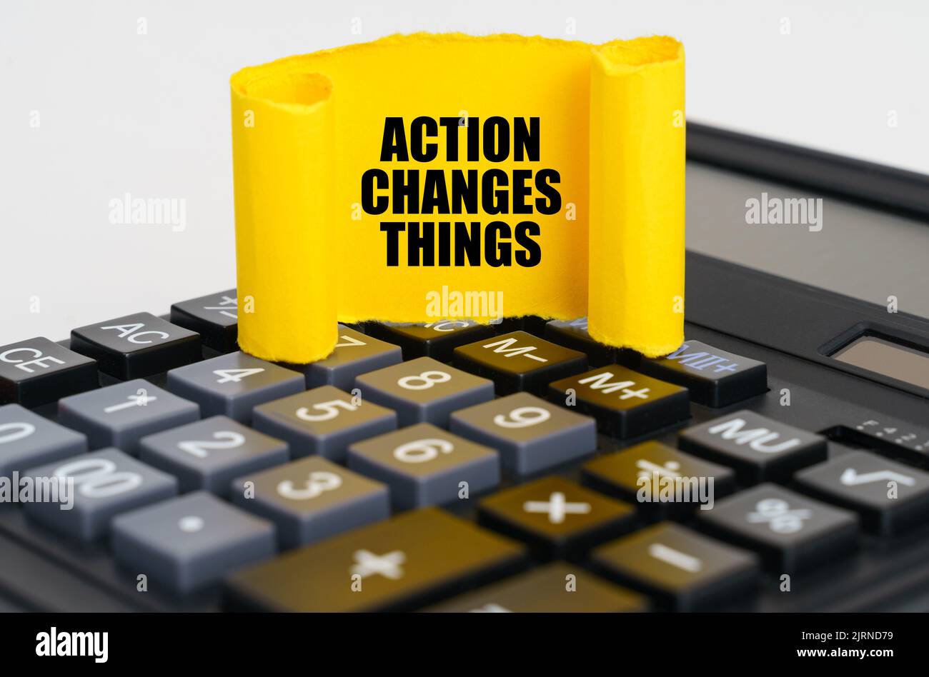 Geschäftskonzept. Auf dem Rechner ist ein gelber, verdrehter Papierteller mit der Aufschrift - Aktion verändert die Dinge Stockfoto