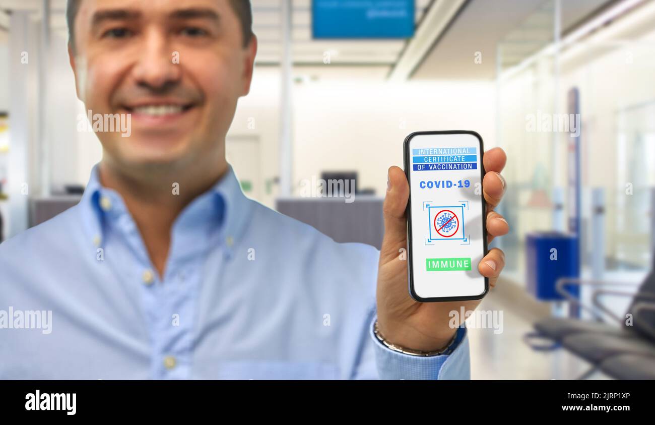 Mann mit Impfpass auf dem Smartphone Stockfoto