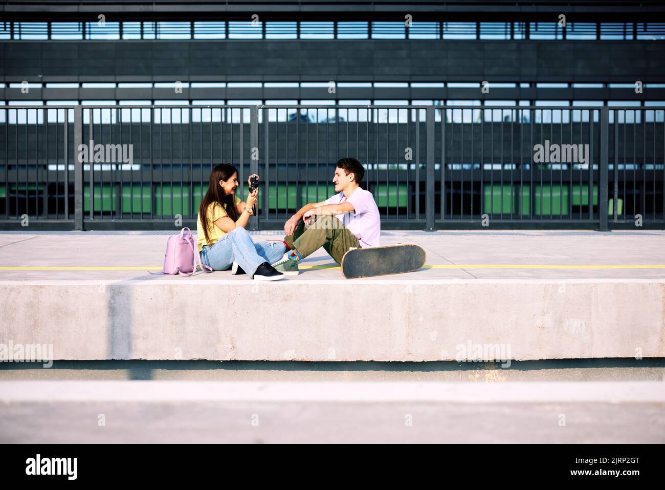 Ein Teenager-Paar sitzt auf dem Bahnhof und fotografiert. Stockfoto