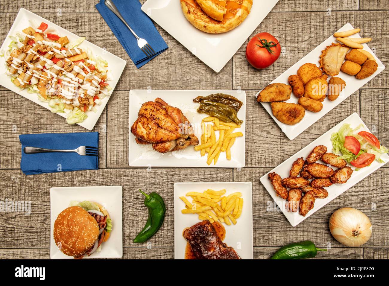 Teller-Set mit köstlichen spanischen Rezepten für Tapas und Chips, gebratene grüne Paprika, Brias Wings, Reis mit Gemüse, Kroketten, Russischer Salat, Chopp Stockfoto