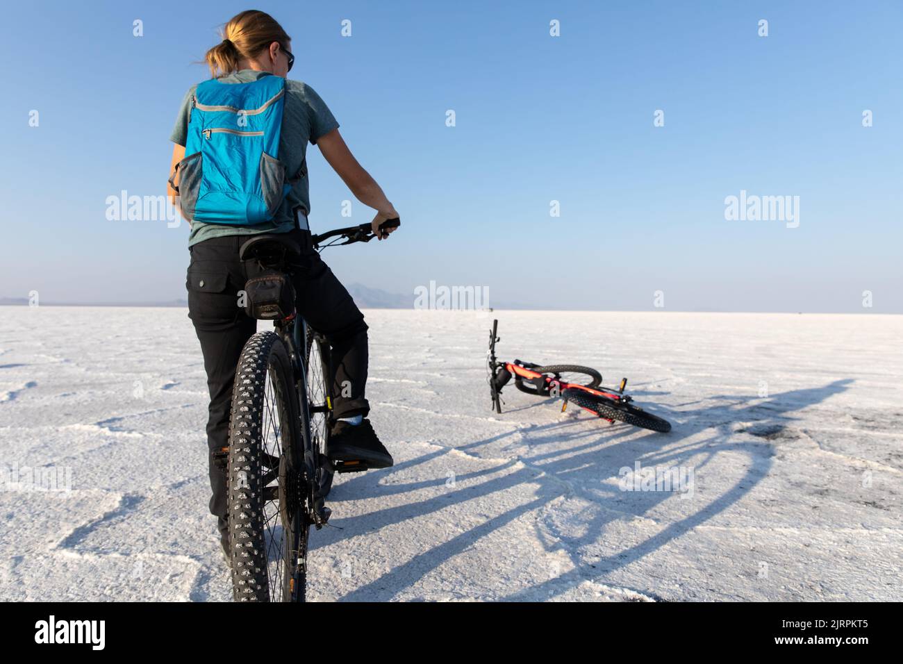 Junge Frau auf einem Fahrrad auf Bonneville Salt Flats in Utah Stockfoto