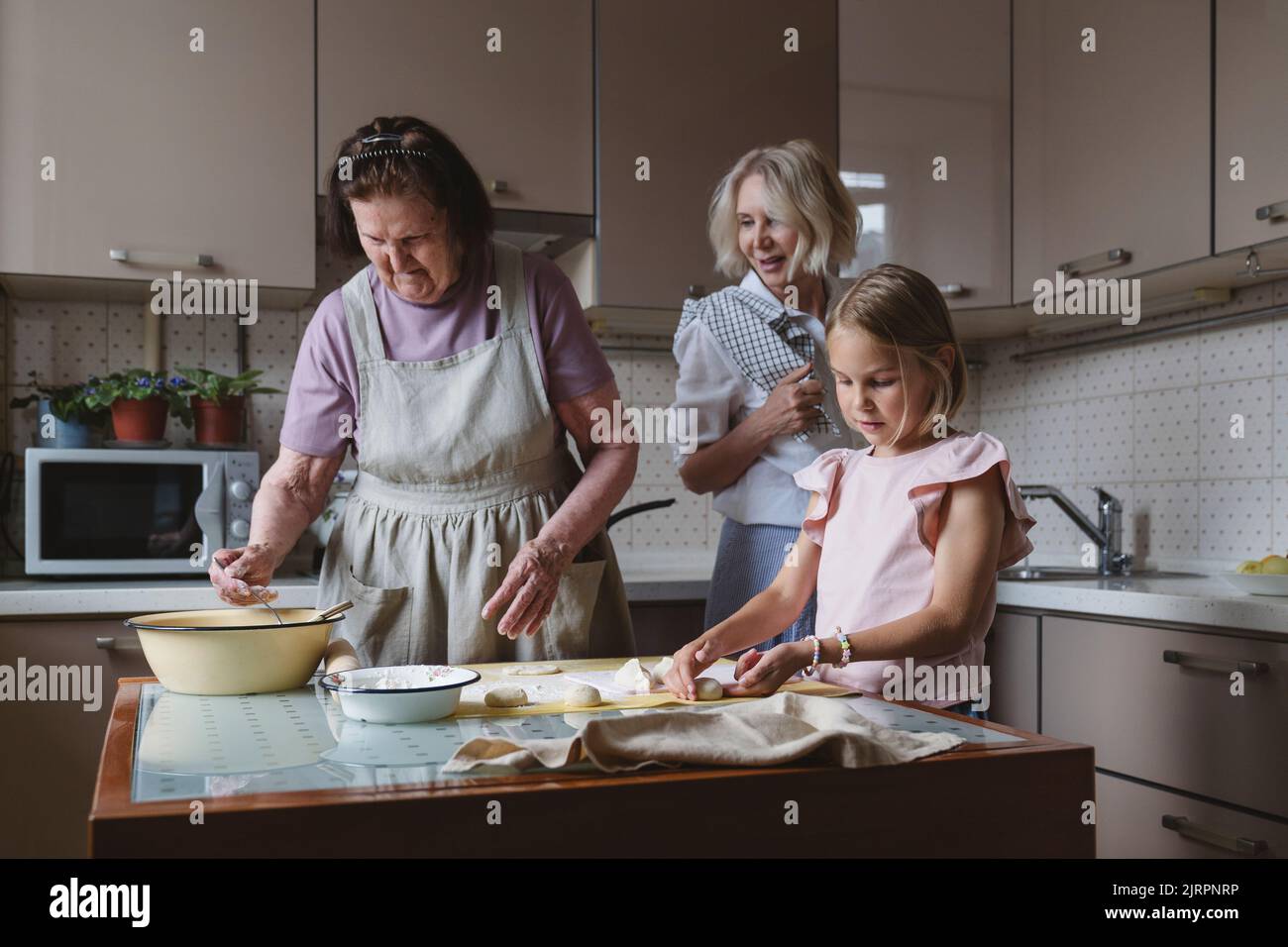 Drei Generationen von Frauen kochen gemeinsam in der Küche. Stockfoto