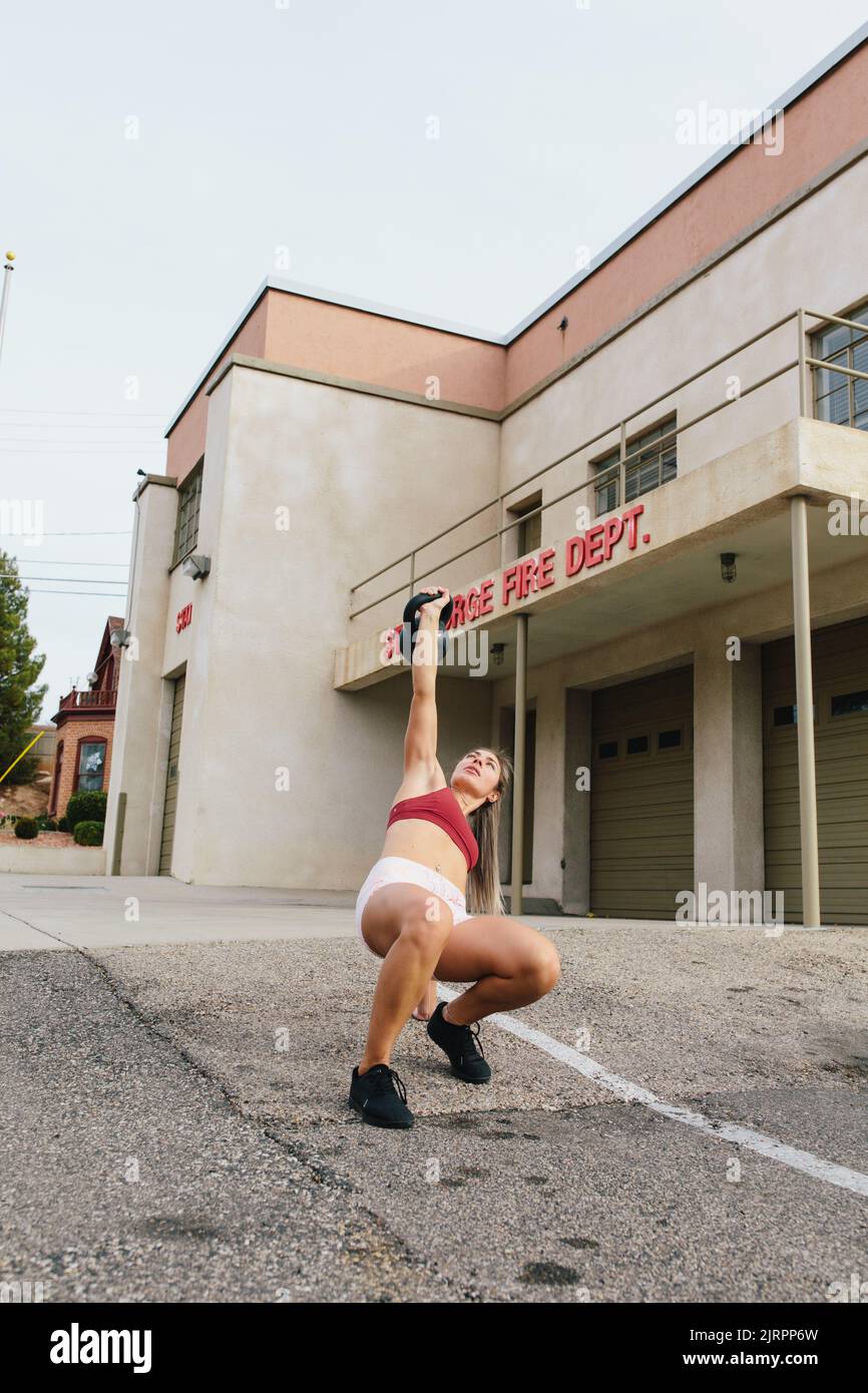 Junge blonde Frau tut Kettlebell türkischen gettup vor o Stockfoto