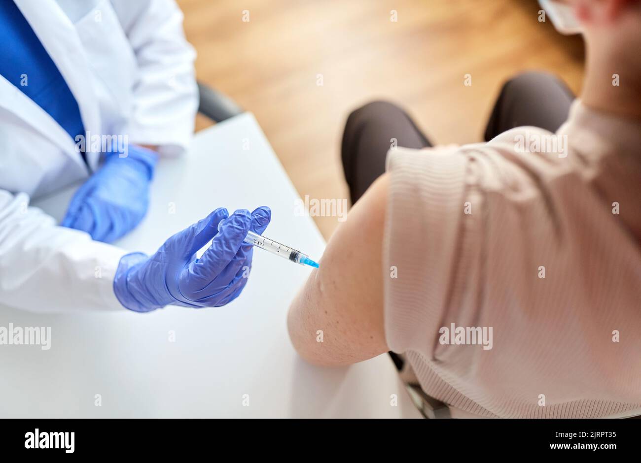 Arzt mit Spritze, die den Patienten impft Stockfoto