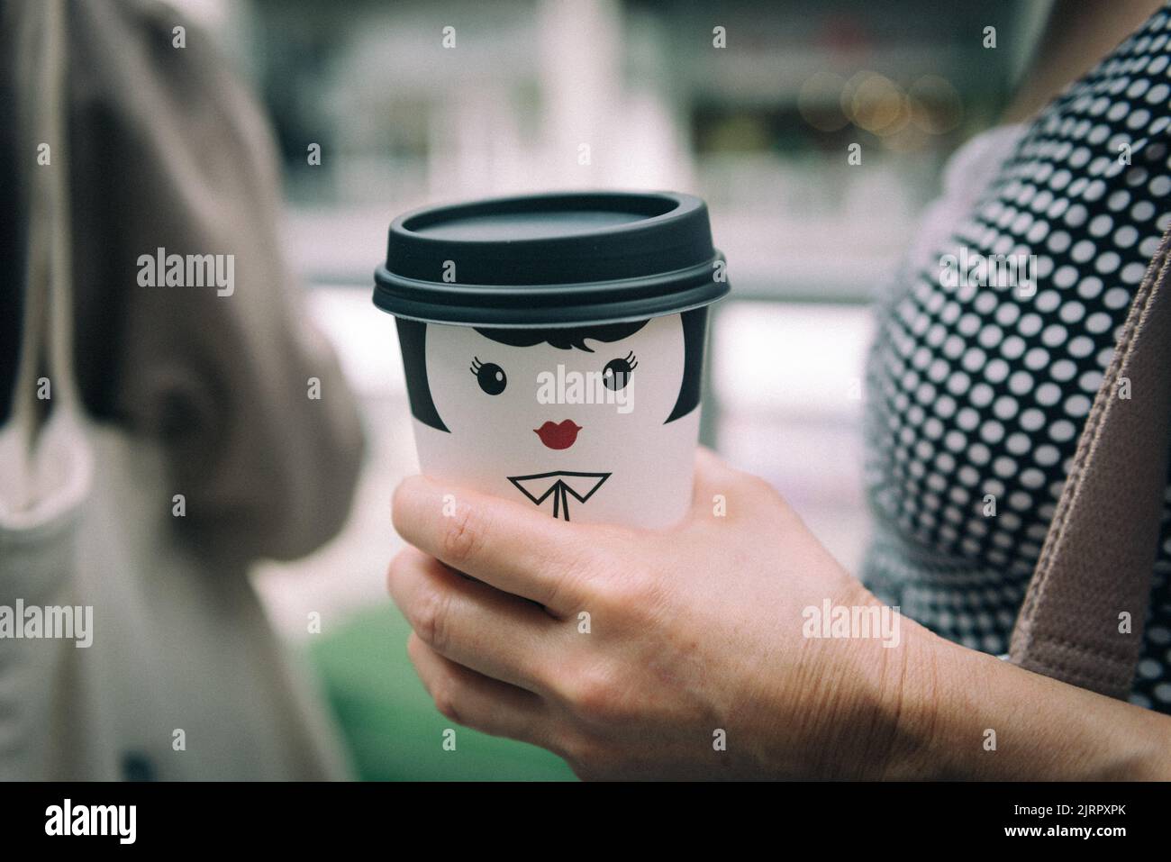 Mädchendruck auf Pappkaffeetasse Stockfoto