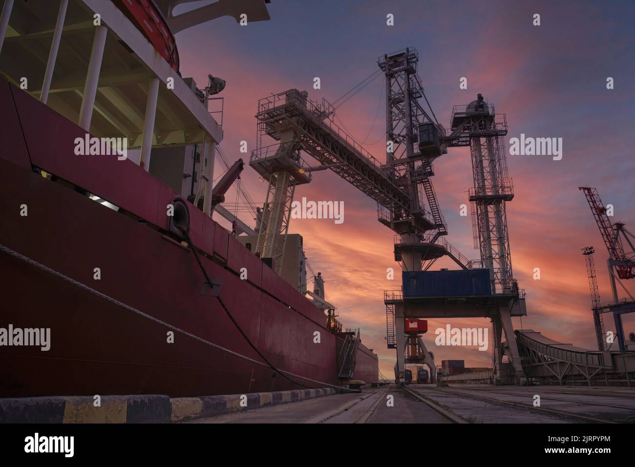 Schüttgutträger am Getreideaufzug im Hafen. Panamax Bulk Carrier mit Weizen beladen. Schiff am Getreideterminal. Hafenaufzug mit Bulk Carrier. Große Industrie Stockfoto