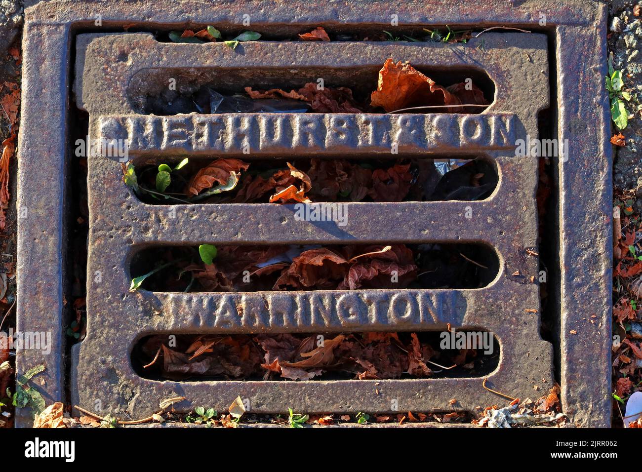 Geprägte gusseiserne Gitterroste aus Gusseisen mit Warrington-Prägung, Cheshire, England, UK, WA1 1NN Stockfoto