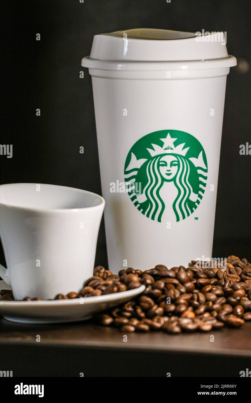 Eine vertikale Aufnahme einer Starbucks Kaffeetasse mit Kaffeebohnen Stockfoto