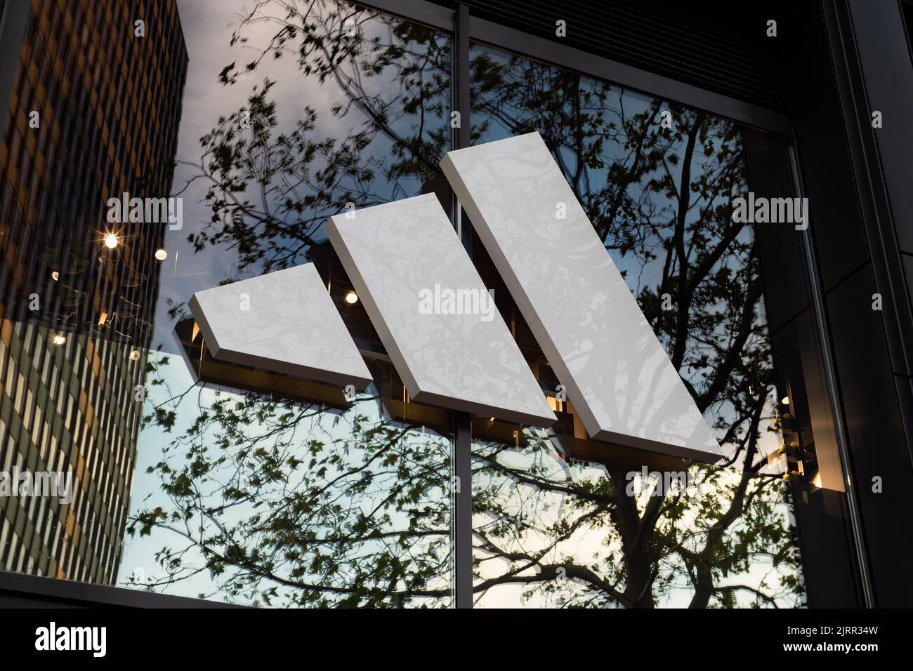 Adidas-Logo auf dem Äußeren eines Gebäudes. Eine große deutsche Modemarke für Schuhe und Sportbekleidung. Der multinationale Konzern kommt aus Bayern. Stockfoto