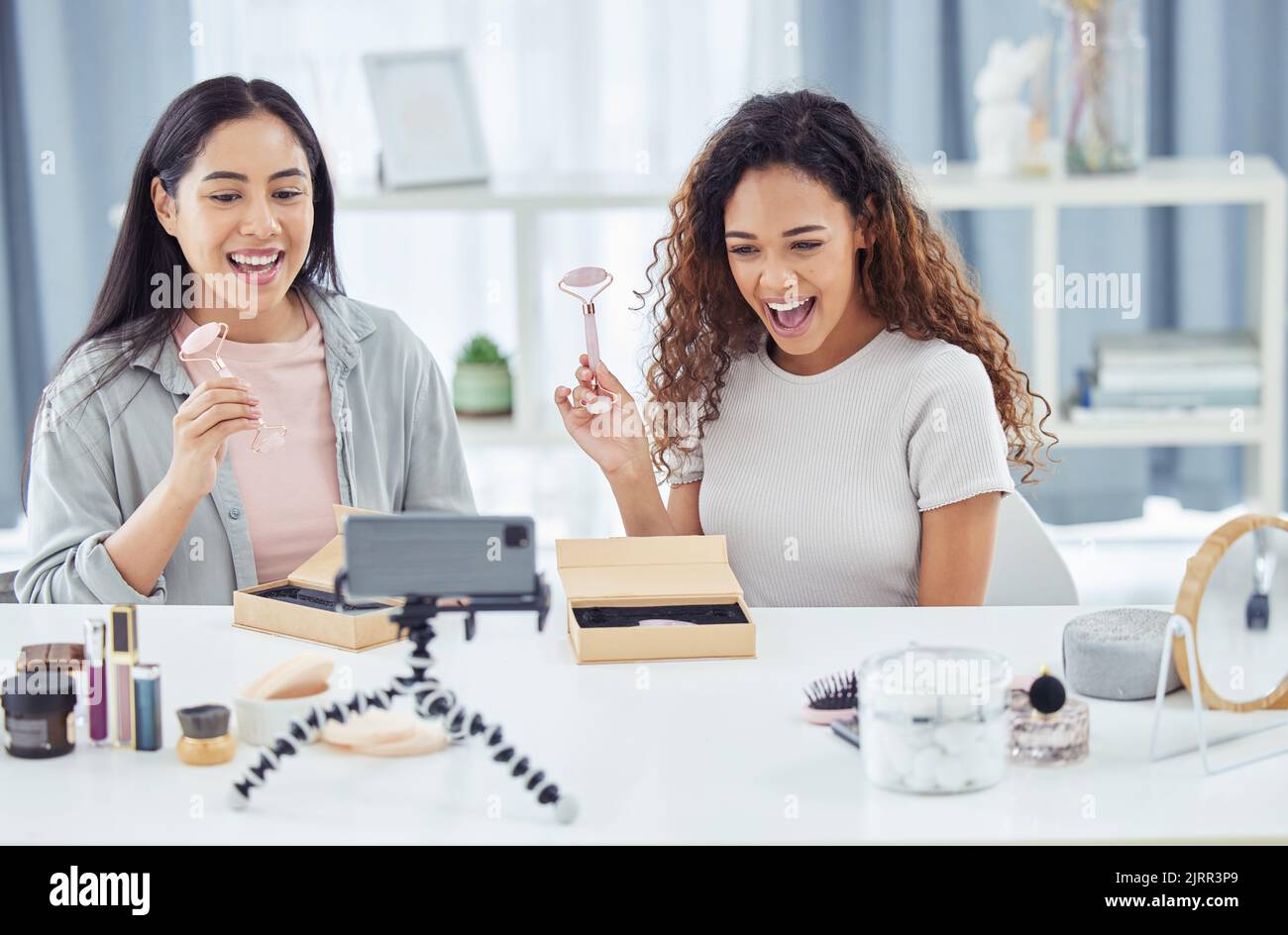 Glücklicher Influencer macht Make-up Review Video Podcast für Online-Beauty-Blog oder vlog mit ihrem Handy zu Hause. Weibliche Content-Ersteller oder Influencer live Stockfoto