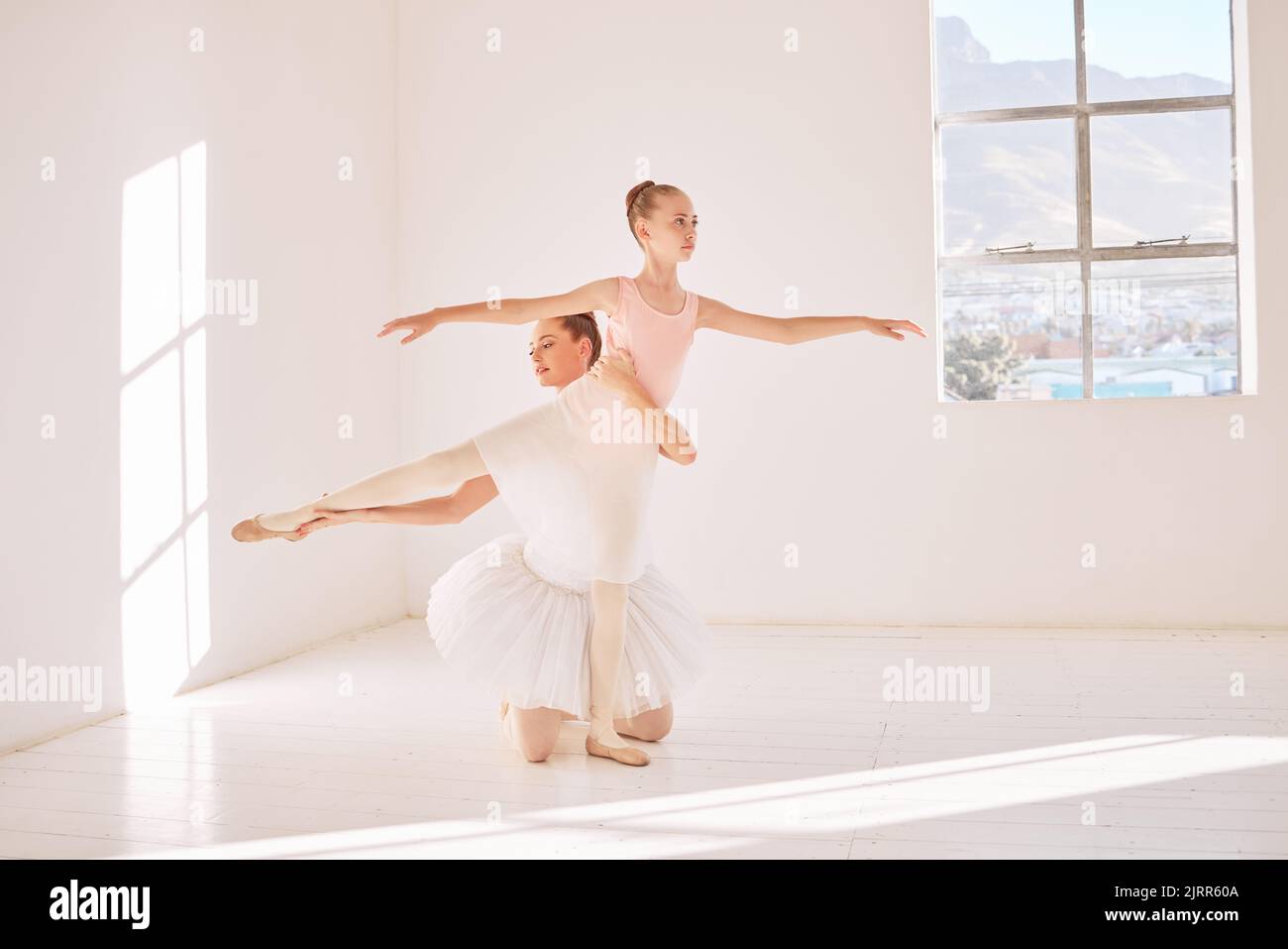 Fitness-, Support- und Ballettlehrer trainiert Ballerina, hilft mit Haltung und Gleichgewicht in einem Tanzstudio. Flexible Mädchen Praxis Routine für elegant Stockfoto