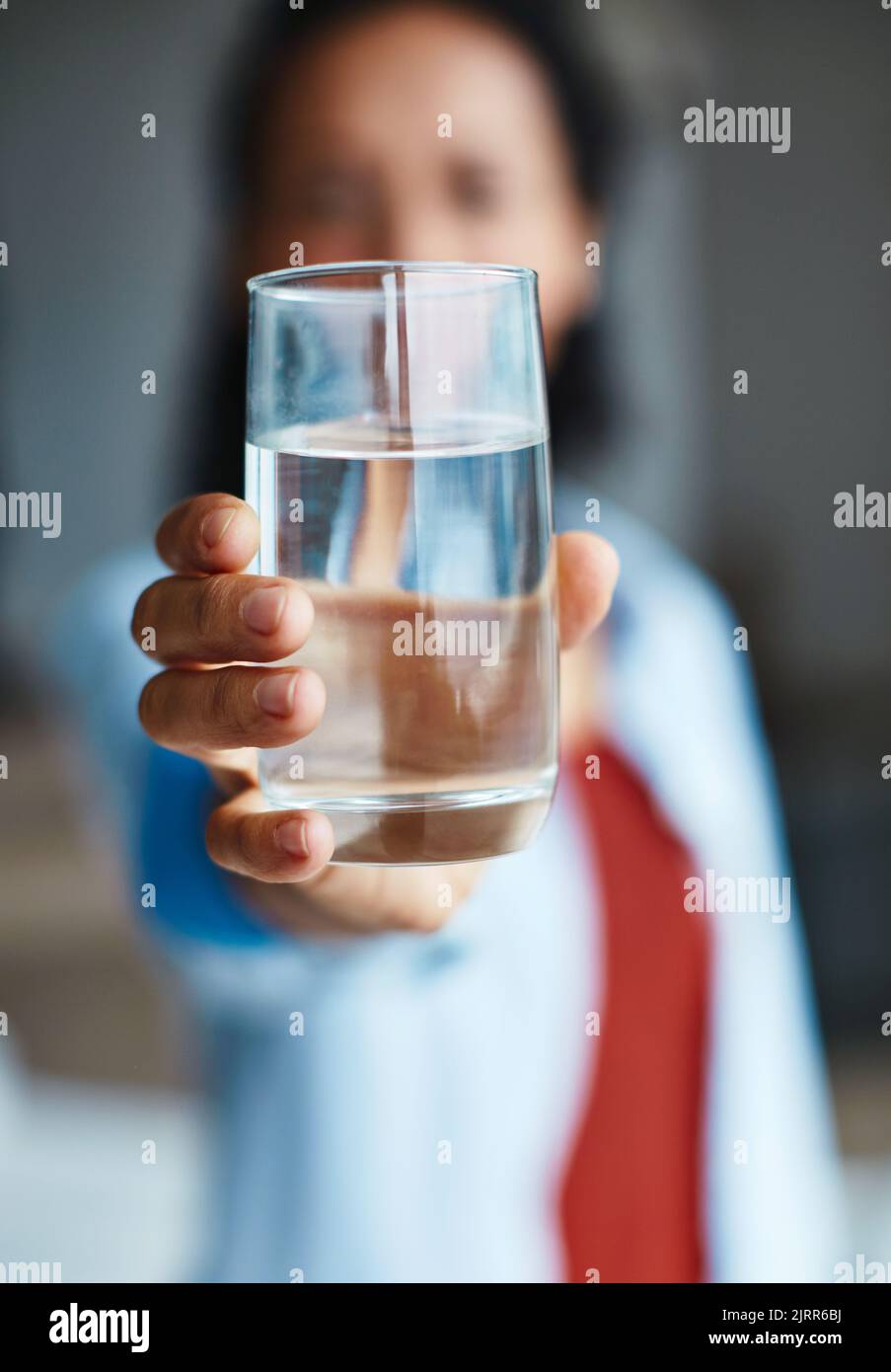 Eine Frau, die zu Hause ein Glas Wasser trinkt. Stockfoto