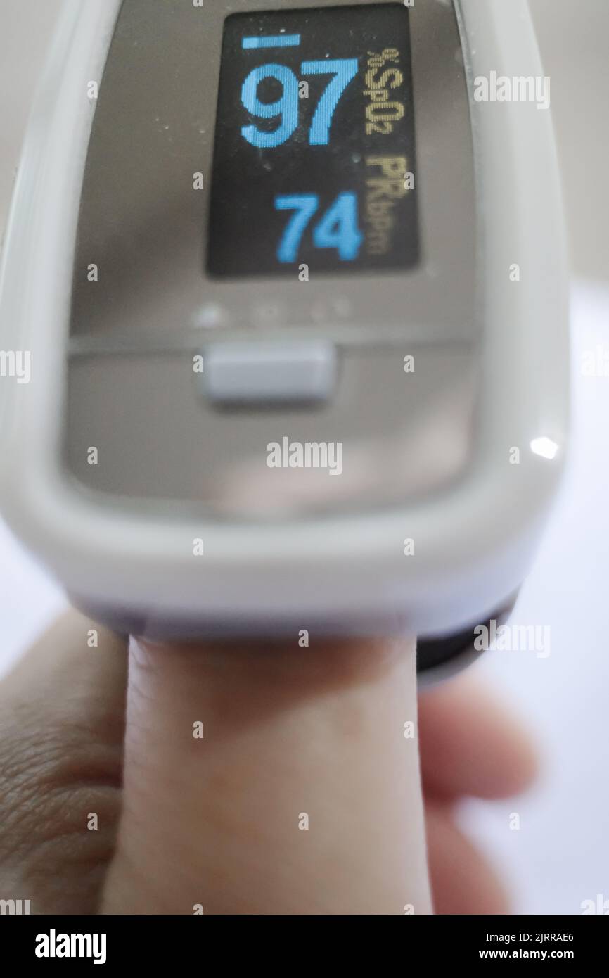 Nahaufnahme mit Oximeter am Daumen zur Messung von Puls und Herzfrequenz Stockfoto