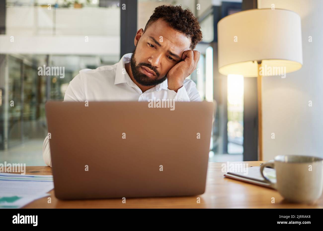 Stress, Burnout und traurige Augen des Geschäftsmannes auf dem Laptop, der zu spät an einer E-Mail zu Hause oder zu Hause arbeitet. Kopfschmerzen, psychische Gesundheit und enttäuschter Arbeiter Stockfoto