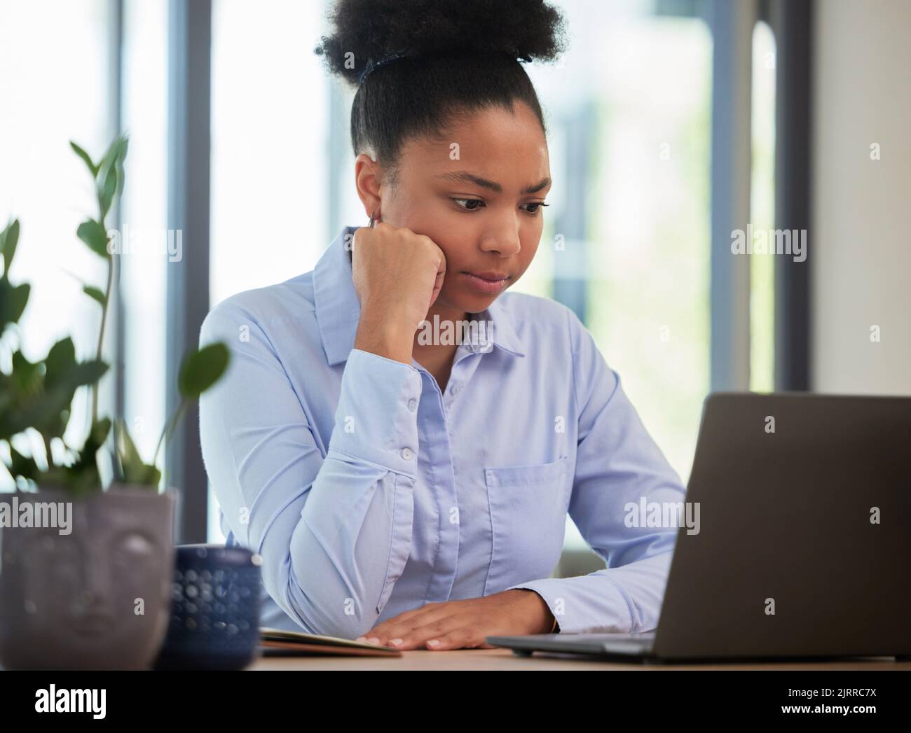 Ernst, frustriert und denkend, während Sie in einem Büro auf einem Laptop mit langsamer Internet- oder WiFi-Verbindung warten und arbeiten. Schwarze Unternehmerin Stockfoto