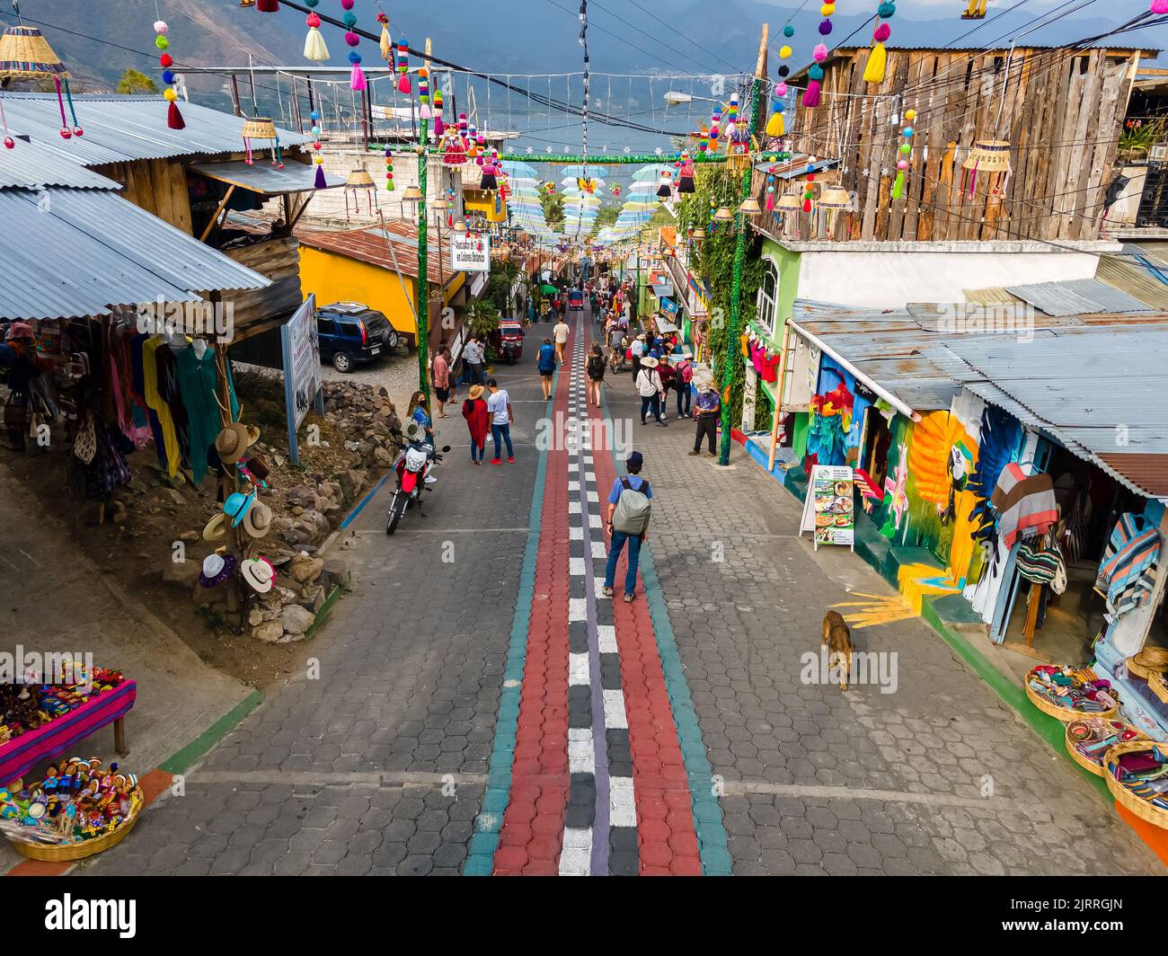 Schöne Luftaufnahme von San Juan la Laguna kleine Stadt im Guatemala Atitlan See - Regenschirmstraßen, bunte Menschen und Touristen Stockfoto