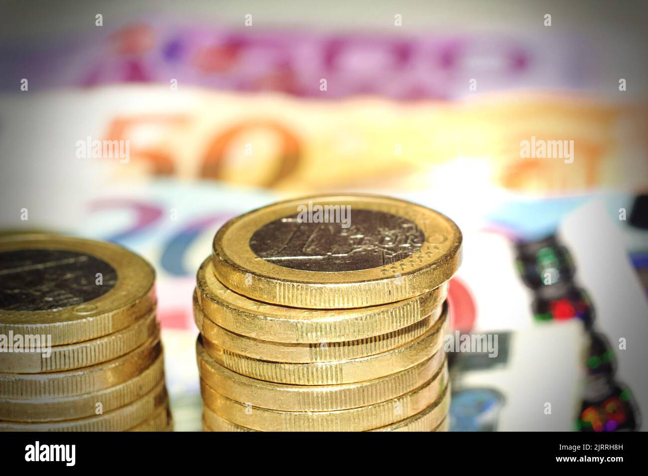Nahaufnahme von Euro-Münzen mit Euro-Scheinen als Hintergrund. Stockfoto