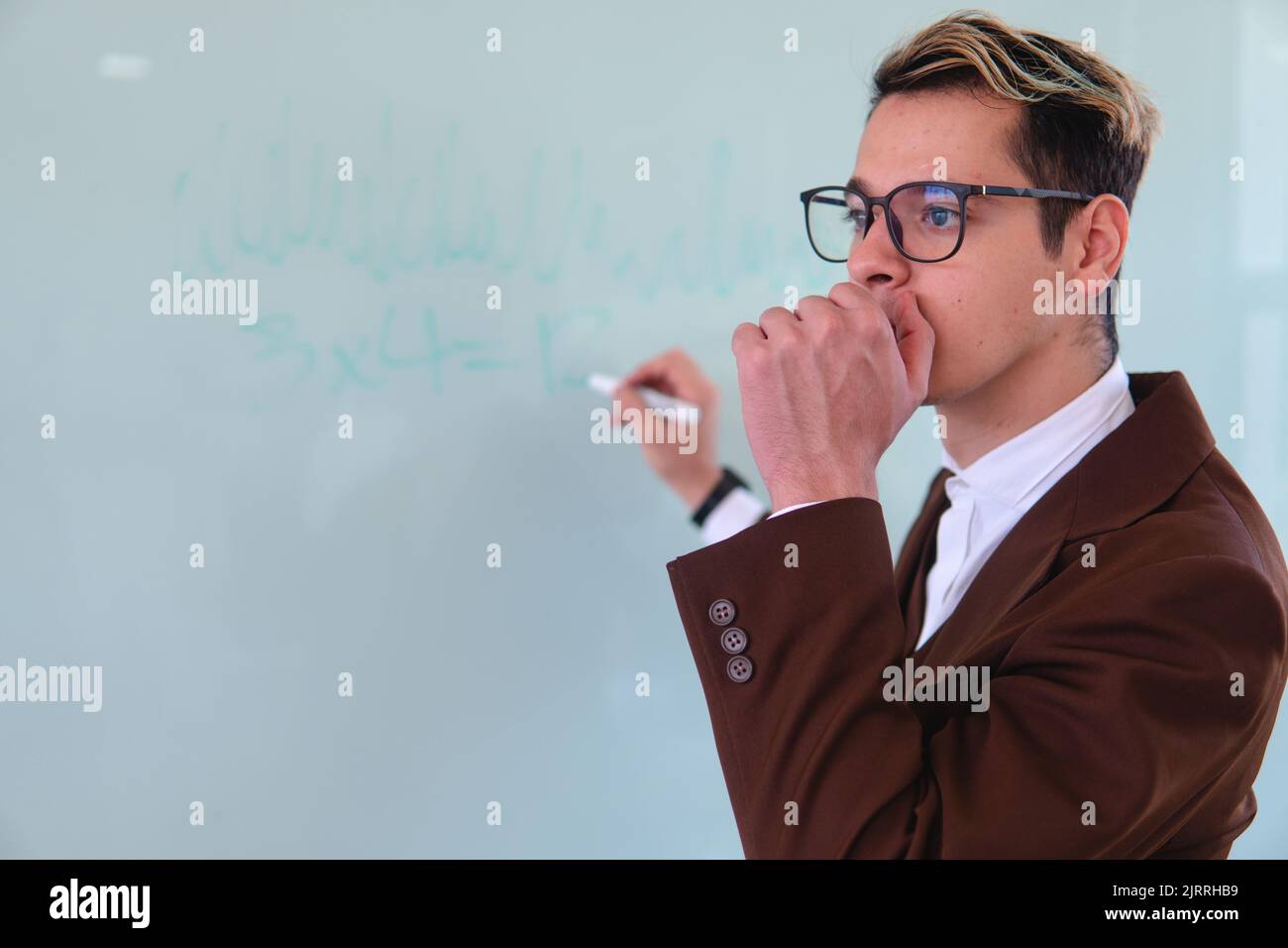 Professor denkt vor dem Whiteboard. Lehrer in der Mitte einer Klasse denken über dich Thema. Kaukasische blonde elegante Lehrerin. Hochwertige Fotos Stockfoto